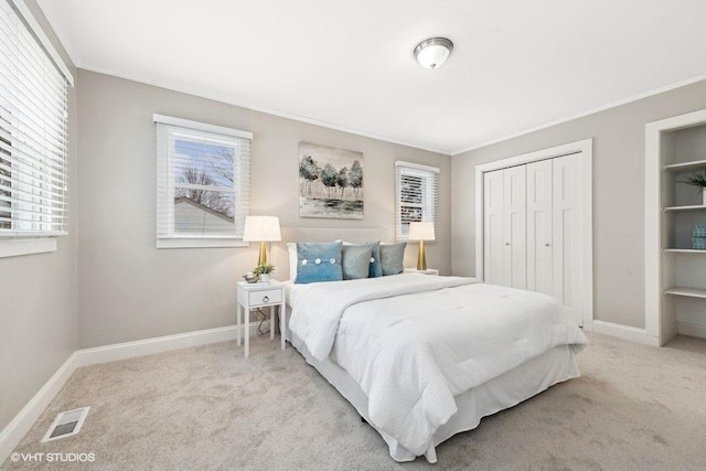 bedroom featuring ornamental molding, light colored carpet, and a closet