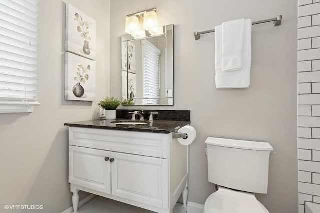 bathroom featuring vanity, a healthy amount of sunlight, and toilet