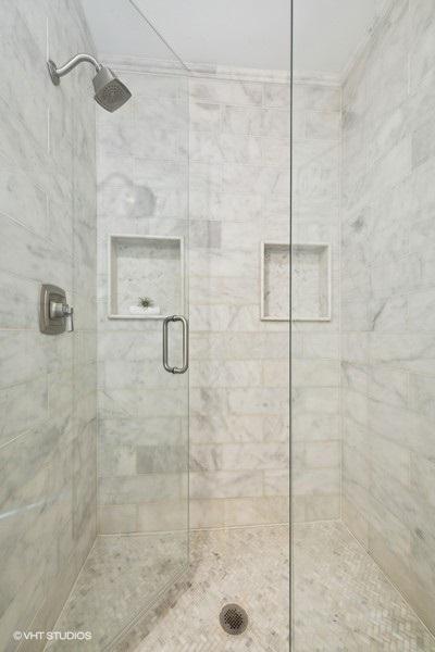 bathroom featuring a shower with door