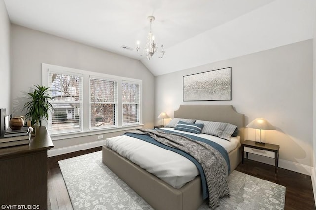 bedroom with vaulted ceiling, dark hardwood / wood-style floors, and a chandelier