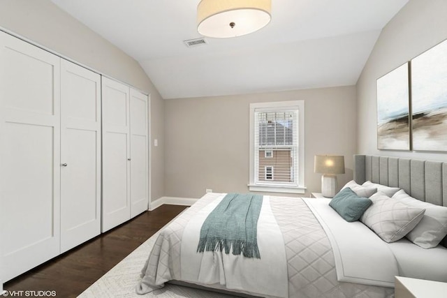 bedroom featuring dark hardwood / wood-style floors, vaulted ceiling, and a closet