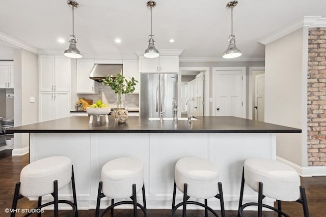 kitchen with hanging light fixtures, white cabinetry, a large island, and stainless steel refrigerator