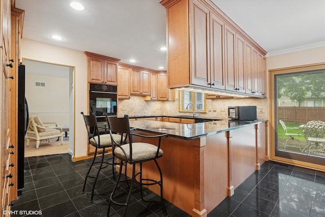 1247 Highpoint Ln, Northbrook, IL 60062 - kitchen with black appliances, backsplash, dark stone countertops, crown molding, and a kitchen bar