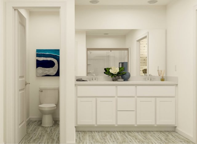 bathroom with vanity, hardwood / wood-style flooring, and toilet