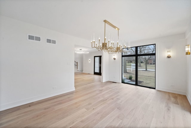 interior space with a notable chandelier and light wood-type flooring