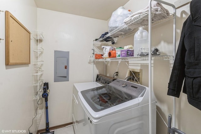 laundry room with washing machine and clothes dryer, electric panel, and light tile patterned floors