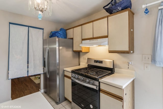 kitchen with hanging light fixtures, light tile patterned floors, a chandelier, and appliances with stainless steel finishes