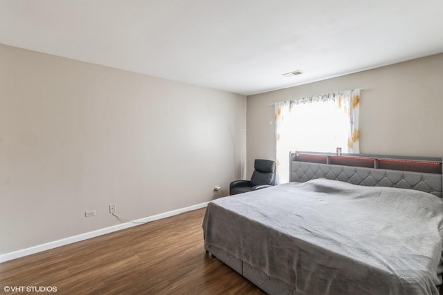 bedroom with dark hardwood / wood-style flooring