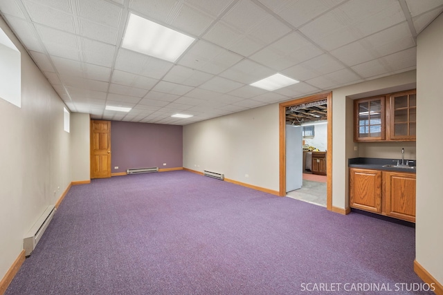 basement with baseboard heating, carpet floors, and sink