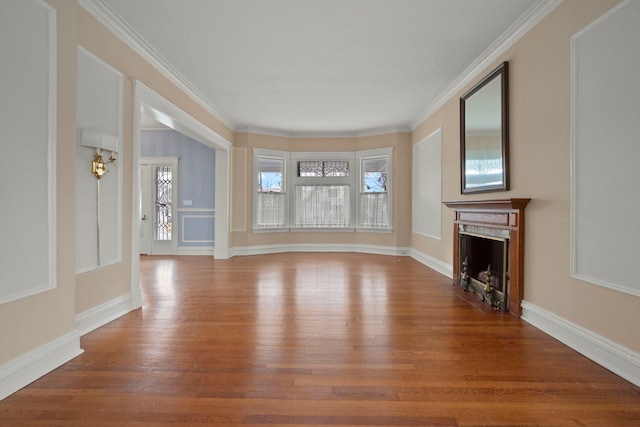 unfurnished living room featuring hardwood / wood-style flooring and ornamental molding