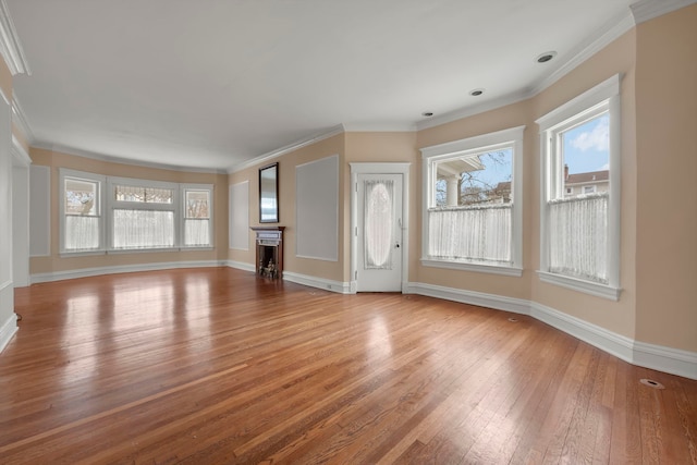 unfurnished living room with wood-type flooring and ornamental molding