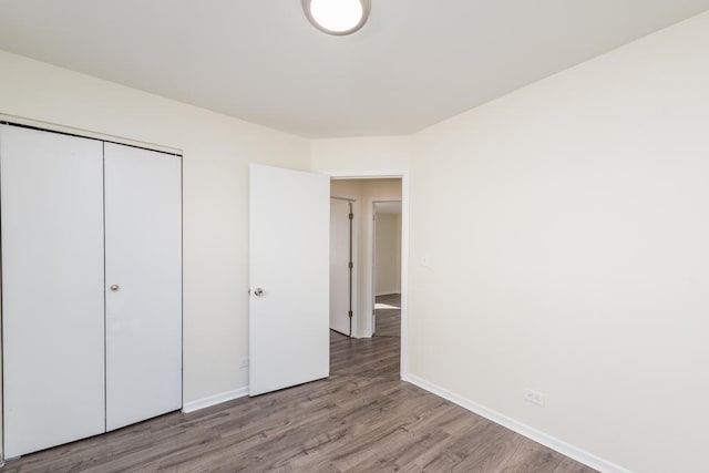 unfurnished bedroom with light hardwood / wood-style flooring and a closet