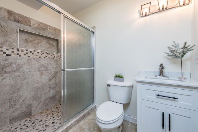 bathroom featuring tile patterned flooring, vanity, walk in shower, and toilet