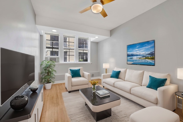 living room featuring light hardwood / wood-style flooring and ceiling fan