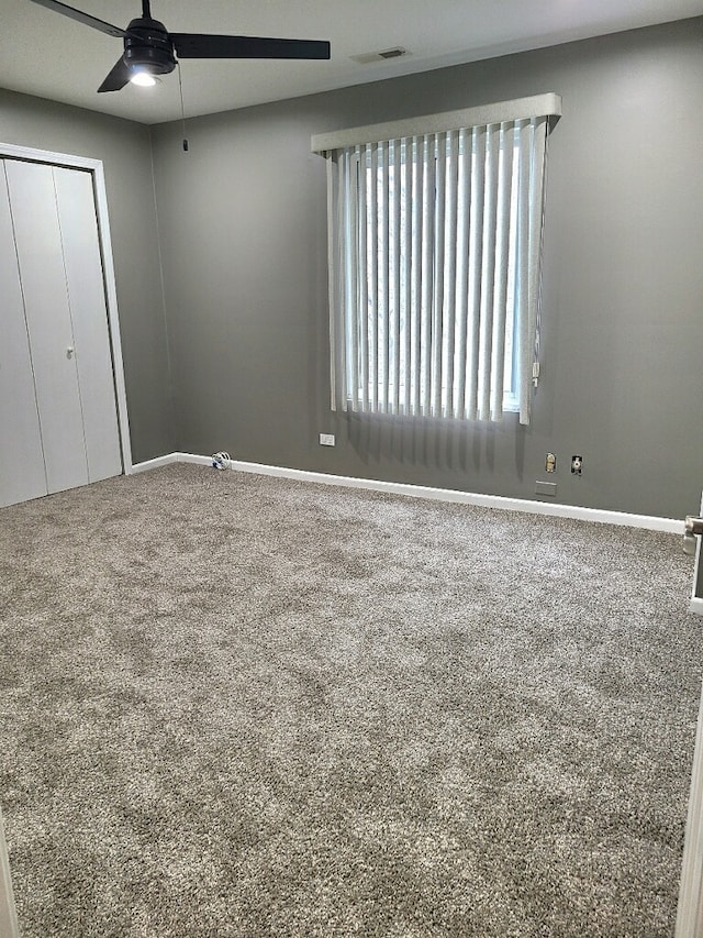 unfurnished bedroom featuring a closet, ceiling fan, and carpet