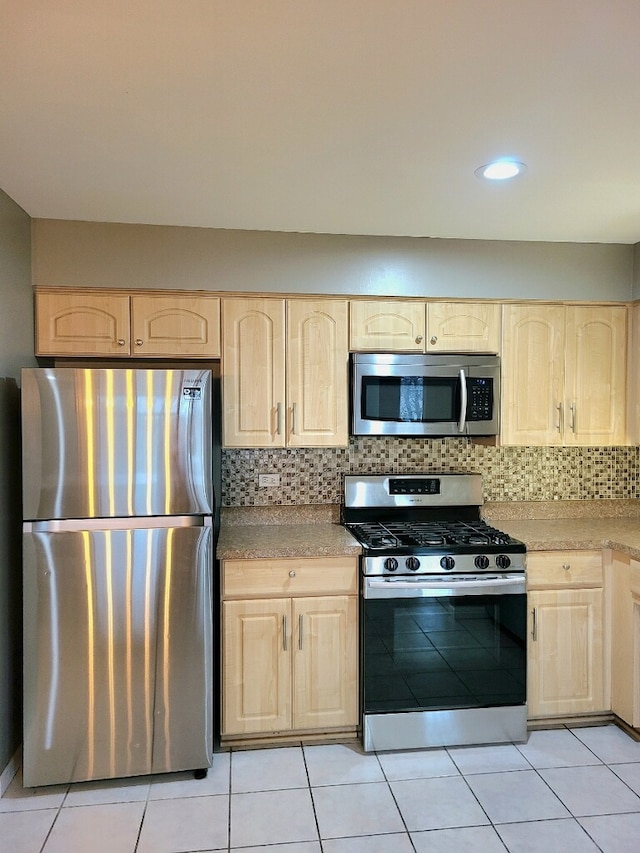 kitchen featuring tasteful backsplash, appliances with stainless steel finishes, and light brown cabinetry