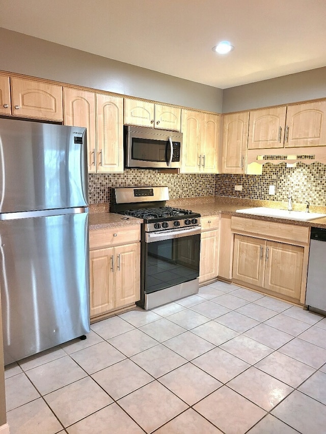 kitchen with tasteful backsplash, stainless steel appliances, and light brown cabinetry