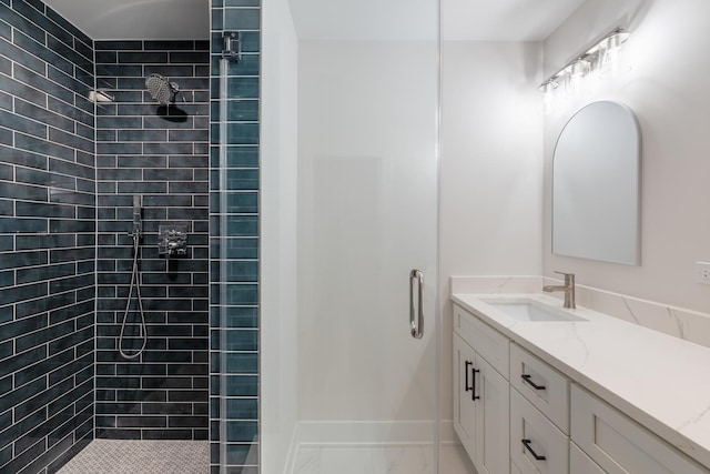 bathroom with a tile shower and vanity