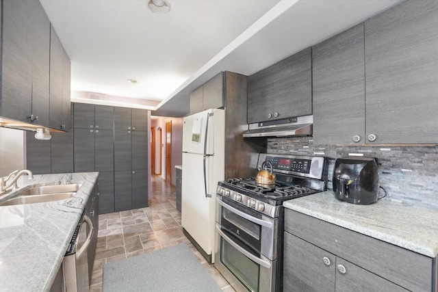 kitchen featuring tasteful backsplash, sink, double oven range, white fridge, and light stone countertops