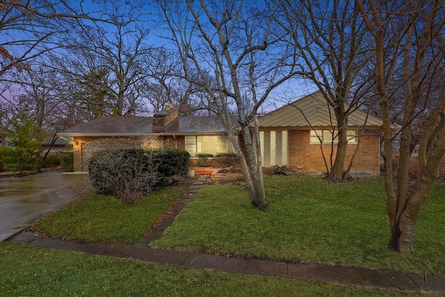 ranch-style house featuring a garage and a lawn