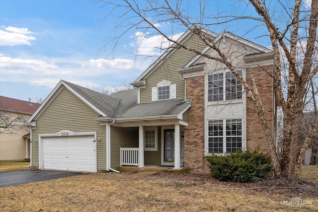 traditional-style home with driveway, covered porch, an attached garage, a shingled roof, and brick siding