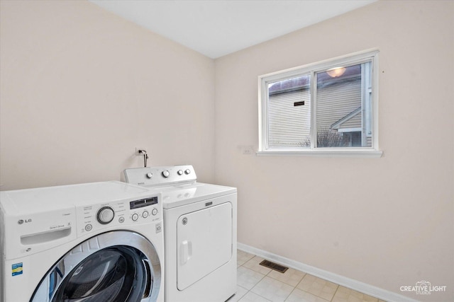 laundry area with laundry area, baseboards, visible vents, and washer and clothes dryer