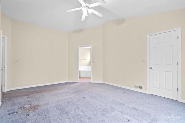 carpeted spare room with visible vents, baseboards, a ceiling fan, and vaulted ceiling