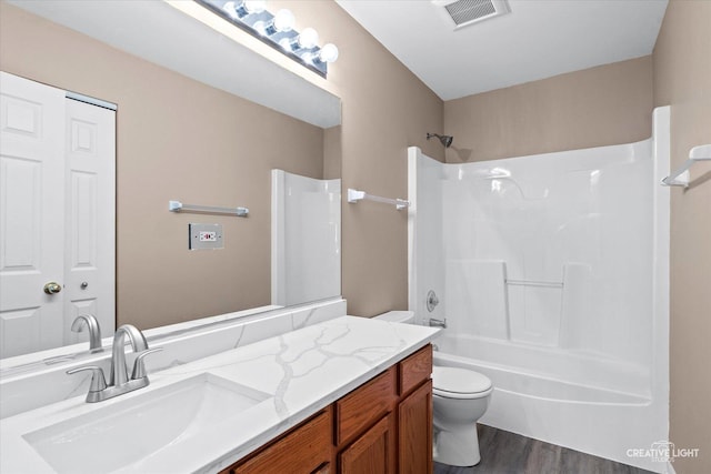 full bath featuring visible vents, toilet, shower / bathing tub combination, wood finished floors, and vanity