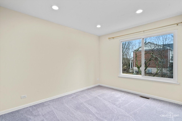 spare room with recessed lighting, carpet, visible vents, and baseboards