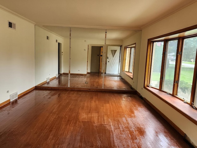 spare room featuring crown molding and hardwood / wood-style floors