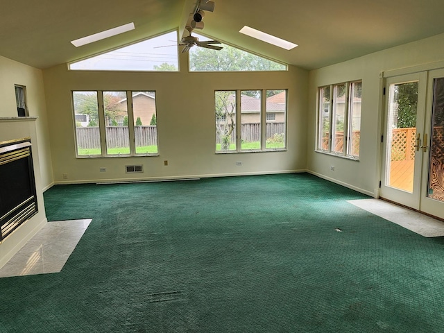 unfurnished living room with lofted ceiling, french doors, and dark colored carpet