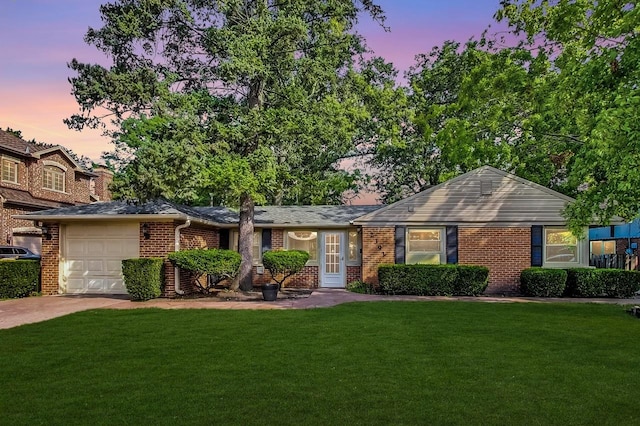 ranch-style home with a yard and a garage