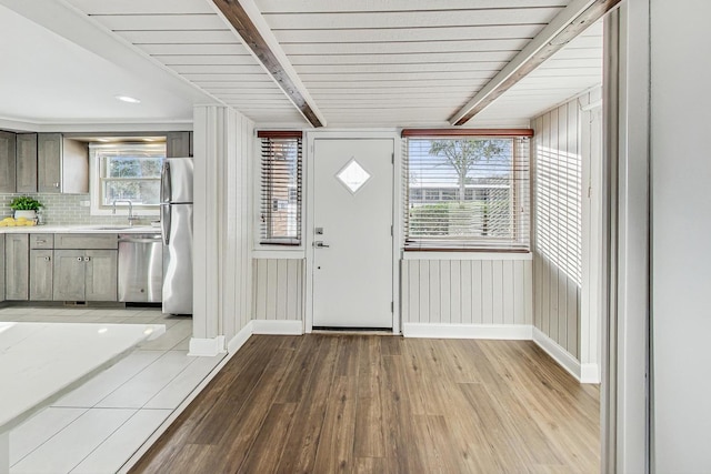 foyer entrance with beamed ceiling, sink, and light hardwood / wood-style flooring