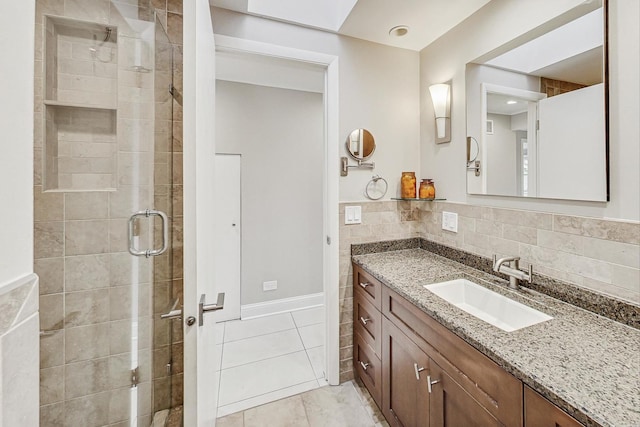 bathroom with an enclosed shower, vanity, tile walls, and tile patterned floors