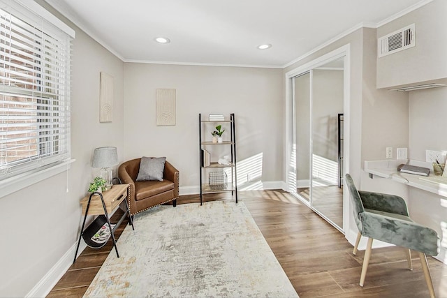 living area with hardwood / wood-style flooring and ornamental molding