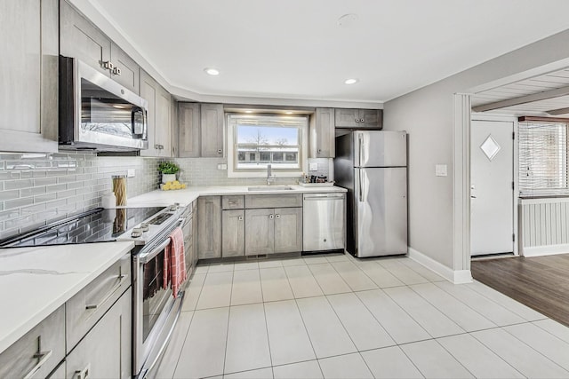 kitchen with sink, decorative backsplash, a wealth of natural light, and stainless steel appliances