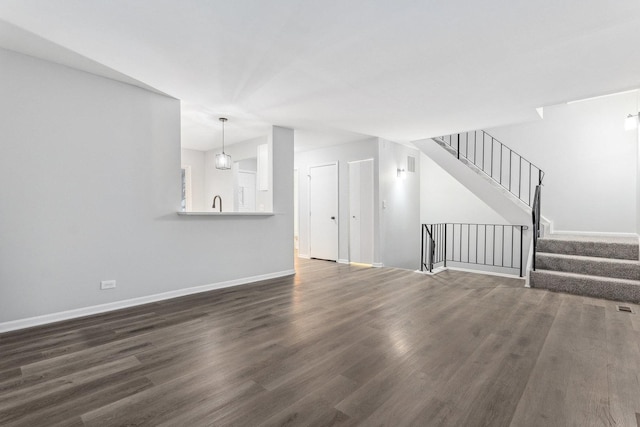 unfurnished living room with dark wood-type flooring