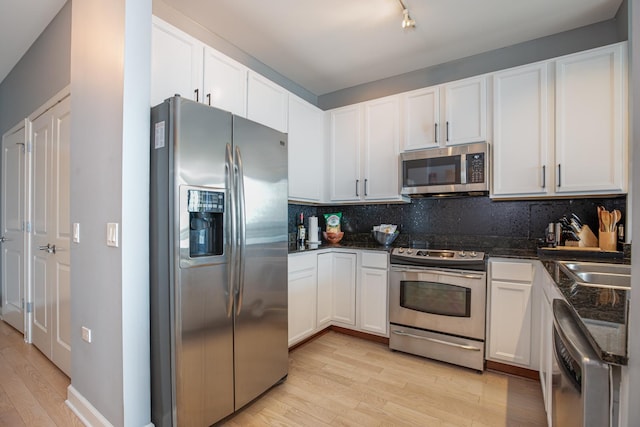 kitchen featuring tasteful backsplash, appliances with stainless steel finishes, and white cabinets