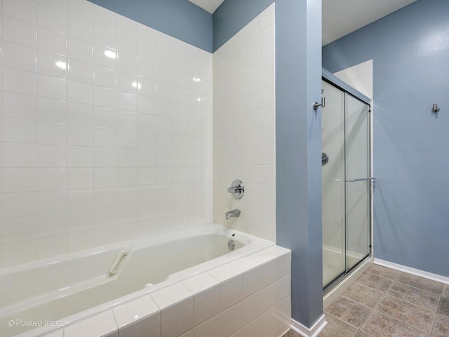 full bathroom with a garden tub, a shower stall, baseboards, and tile patterned flooring