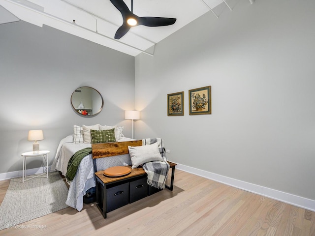 bedroom featuring a ceiling fan, baseboards, and wood finished floors