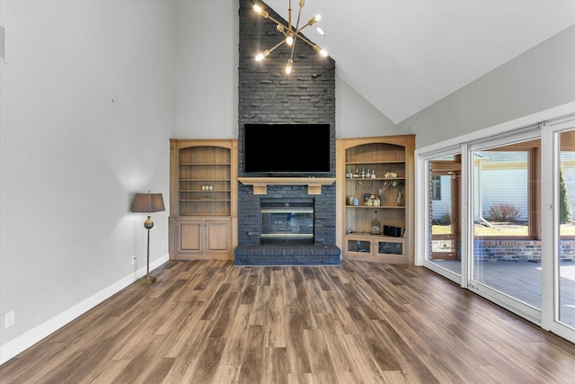 1801 Cobblefield Ct, Champaign, IL 61822 - unfurnished living room with high vaulted ceiling, a brick fireplace, wood finished floors, a chandelier, and baseboards