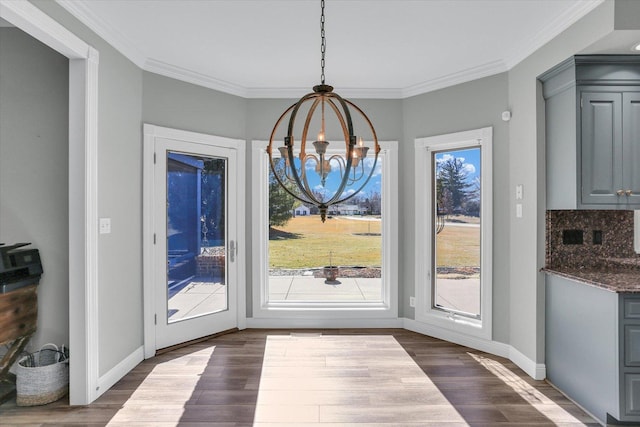 1801 Cobblefield Ct, Champaign, IL 61822 - unfurnished dining area with a chandelier, dark wood finished floors, plenty of natural light, and crown molding