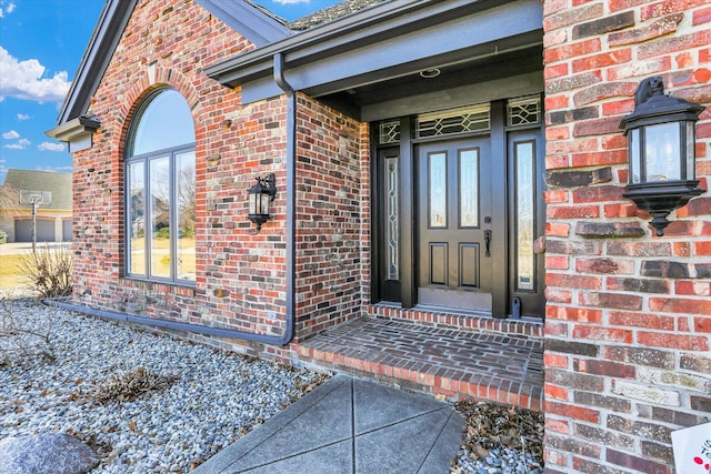 view of exterior entry with brick siding