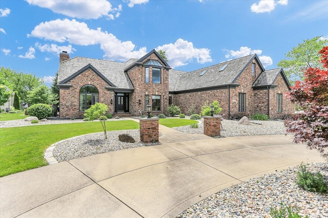 1801 Cobblefield Ct, Champaign, IL 61822 - tudor-style house featuring brick siding, a chimney, a front lawn, and a high end roof