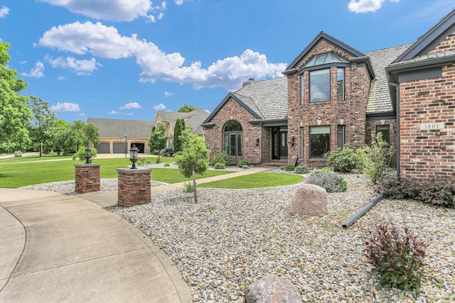 1801 Cobblefield Ct, Champaign, IL 61822 - view of front of house with brick siding, a front lawn, and a chimney
