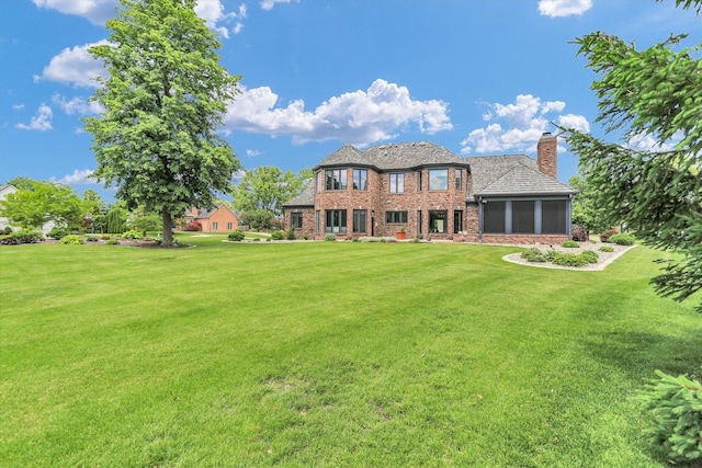 1801 Cobblefield Ct, Champaign, IL 61822 - back of house with a yard, a chimney, brick siding, and a sunroom