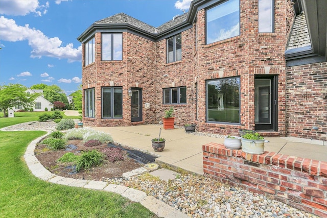 1801 Cobblefield Ct, Champaign, IL 61822 - rear view of property with a patio area, brick siding, a high end roof, and a lawn