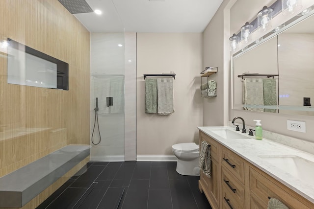 bathroom featuring vanity, a tile shower, tile patterned floors, and toilet