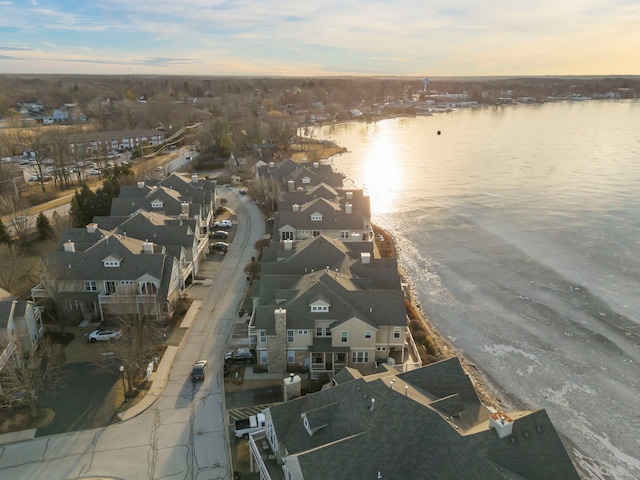 aerial view at dusk featuring a water view