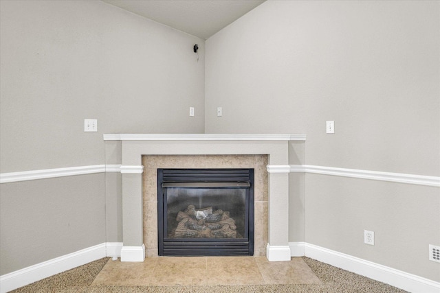 details featuring a tile fireplace and baseboards